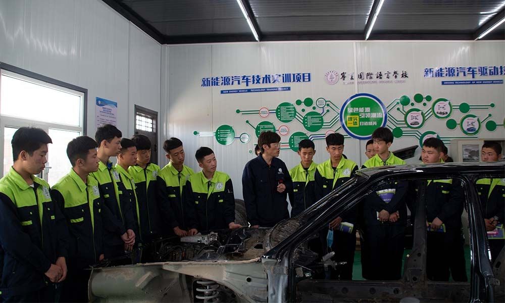 The teacher is training students how to repair new energy vehicles